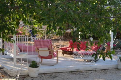 a group of chairs and a couch under a tree at I Trulli Di Acquarossa in Cisternino
