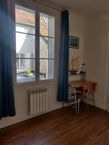 Cette chambre comprend un bureau, une fenêtre et une table. dans l'établissement La tranquillité proche des châteaux de la Loire., à Vendôme