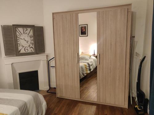 - une grande porte en bois dans une chambre avec un lit dans l'établissement La tranquillité proche des châteaux de la Loire., à Vendôme