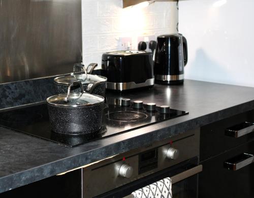 a kitchen with a stove with pots and pans on it at Glamorous Two bed room flat in London