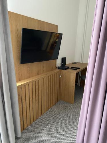 a room with a flat screen tv on a wooden stand at Nasze Kamienice Apartament Rodzinny in Rzeszów