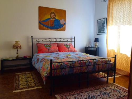 a bedroom with a bed with a painting on the wall at L'Angolo Divino in Casella