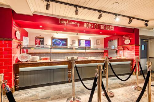 a restaurant with a kitchen with a counter and a counter at Toby Carvery Edinburgh West by Innkeeper's Collection in Edinburgh