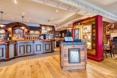 a bar in a pub with a sign in the middle at Toby Carvery Edinburgh West by Innkeeper's Collection in Edinburgh