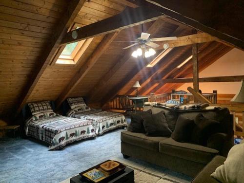 um quarto no sótão com 2 camas e um sofá em Bearadise Cabin em Terra Alta