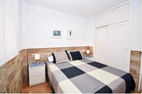 um quarto com uma cama xadrez em preto e branco em Apartamento La Barrosa em Chiclana de la Frontera
