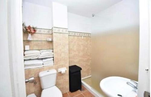 y baño con aseo blanco y lavamanos. en Apartamento La Barrosa, en Chiclana de la Frontera