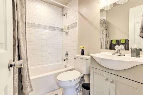 a white bathroom with a toilet and a sink at Newly Renovated, Quaint, Modern 2-Bedroom Loft in Front Royal