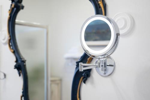 a mirror hanging on a wall next to a shower at Fattoria Pian Di Rocca in Castiglione della Pescaia