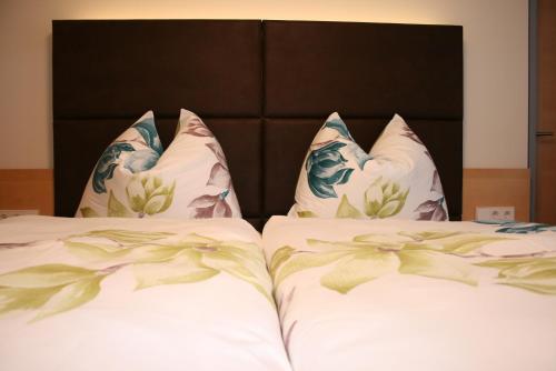 two beds with white sheets and pillows at Gasthof Alpenblick in Amstetten