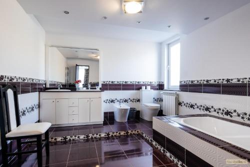 a large bathroom with a tub and two toilets at Sweet Home Bucovina- Baza perfecta pentru explorarea Bucovinei in Frasin