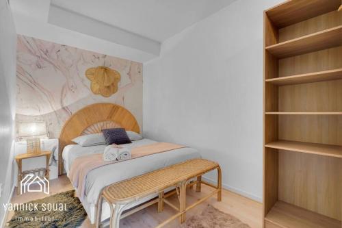 a bedroom with a bed with a bench in it at L'ORMEAU FLAMINGO in Toulouse