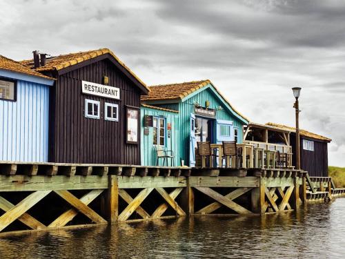 une rangée de maisons sur un quai sur l'eau dans l'établissement Appartement Cosy à Dolus-d'Oléron - 4 Couchages, Proche Plage avec Balcon et Parking Gratuit - FR-1-246A-141, à Dolus-d'Oléron