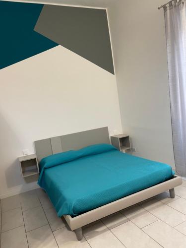 um quarto com uma cama com um cobertor azul em MONOLOCALE PIAZZA FONTANA GRANDE ALLOGGIO TURISTICO em Viterbo