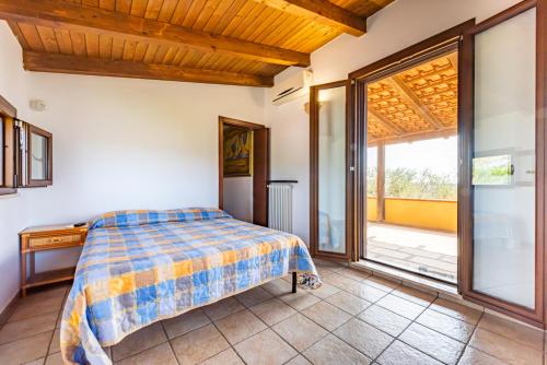 a bedroom with a bed and a large window at Villa Rita in Racale
