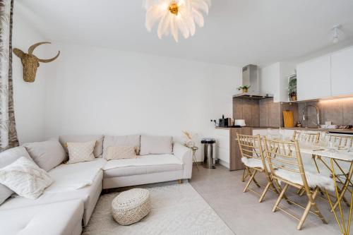 a living room with a white couch and a kitchen at Le Bohème - Charming apartment in the city centre in Annecy