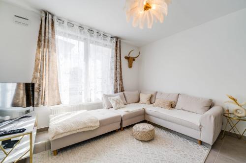 a white living room with a couch and a window at Le Bohème - Charming apartment in the city centre in Annecy