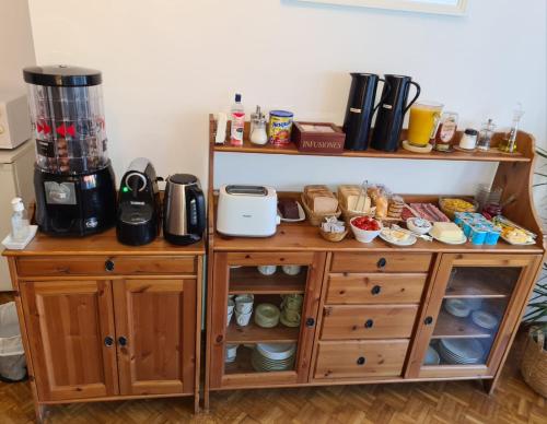 a wooden cabinet with a coffee maker on top of it at Ally's Bed&Breakfast, in Barcelona