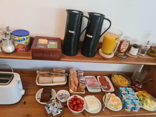 a wooden shelf with breakfast foods and drinks on it at Ally's Bed&Breakfast, in Barcelona