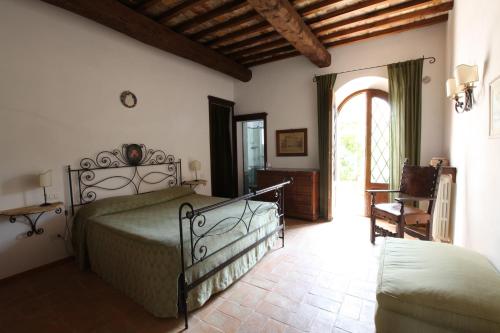 um quarto com uma cama e uma cadeira num quarto em Agriturismo San Gallo em Montepulciano