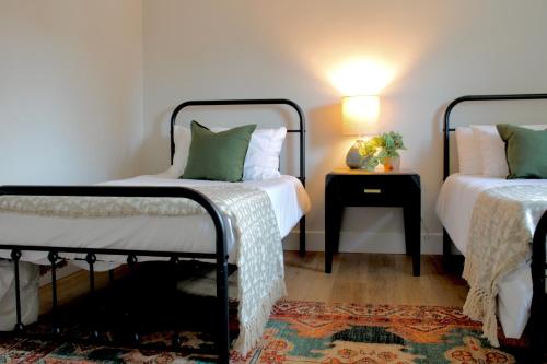 a bedroom with two beds and a night stand with a lamp at Kinnikinnik Motor Lodge in Estes Park