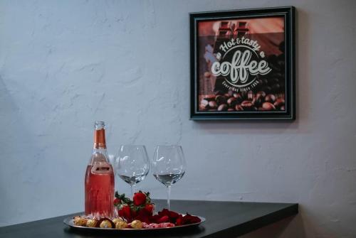 アヴェイロにあるBird’s Homeのワイングラス2杯と食器一皿付きのテーブル