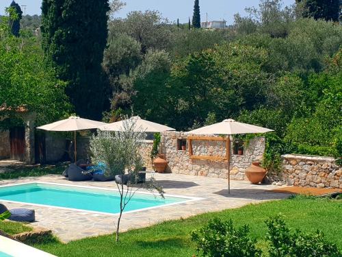 una piscina con sombrillas en un patio en Cottage with Private Pool, en Poros