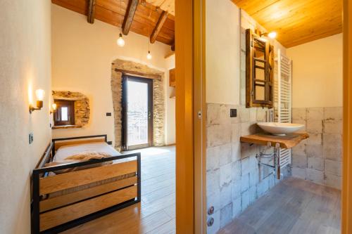 Habitación con baño con cama y lavabo. en Country House Le Gaie Allegre, en Villar San Costanzo