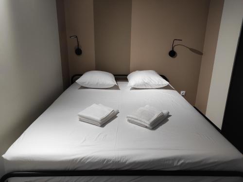 a large white bed with two pillows on it at Apparts'hôtel la ferme du gros noyer in Malaucène