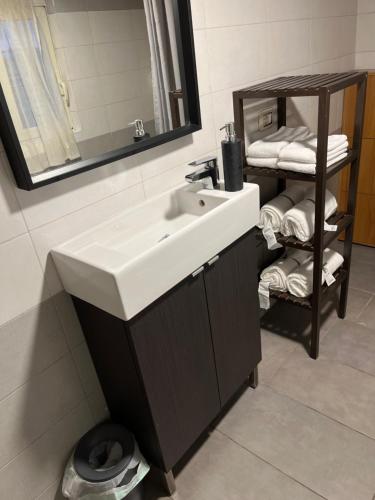 uma casa de banho com um lavatório e uma prateleira com toalhas em San Lorenzo Apartment em Roma