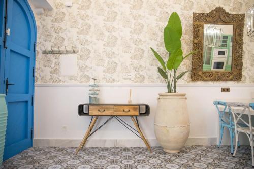 une table dans une pièce avec une plante dans un vase dans l'établissement Golddem Blue, à Torremolinos