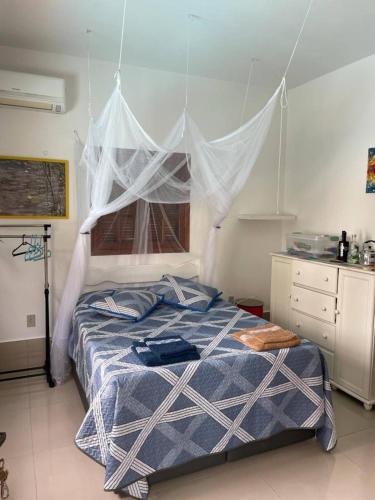 a bedroom with a bed with a net above it at Charmosa suíte de Tucuns. in Búzios