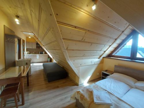 an attic bedroom with a bed and a staircase at Villa TATRIA in Witów
