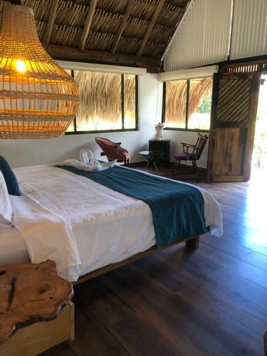 a bedroom with a large bed in a room with windows at Rancho Ecoturistico el Faro in La Mesa