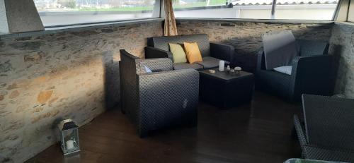 a room with two chairs and a couch and a table at El Rato Apartamentos Rurales in Navia
