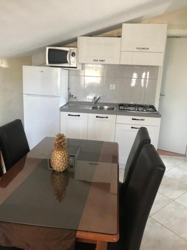 a kitchen with a table with chairs and a sink at Apartments Barbara in Poreč