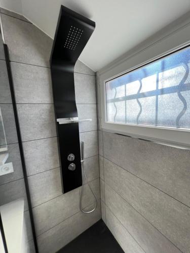 uma casa de banho com um chuveiro e uma janela em Maison de pêcheur à 2 min de la Baie em Le Crotoy