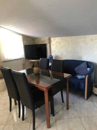 a dining room with a table and a blue couch at Apartments Barbara in Poreč