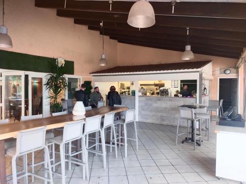 un restaurant avec un bar doté de tabourets blancs dans l'établissement MOBIL HOME LE STEPHANOIS VALRAS, à Valras-Plage