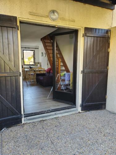eine offene Tür eines Hauses mit einer Treppe in der Unterkunft maison de la plage in Le Grau-du-Roi