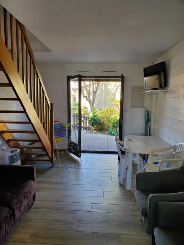 maison de la plage في لو غراو دو روا: غرفة معيشة مع طاولة وكراسي ودرج
