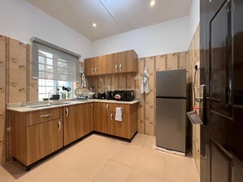 a kitchen with wooden cabinets and a stainless steel refrigerator at The EDEN in Lagos