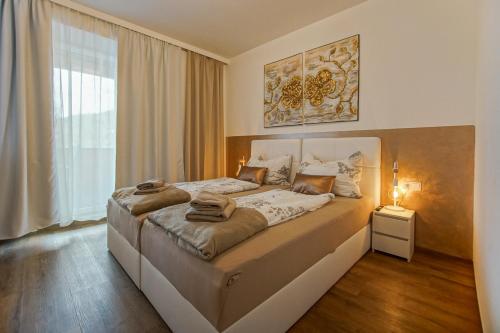 um quarto com uma cama grande e uma janela grande em AusZeit Steiraland 8 mit überdachten Balkon und Parkplatz em Leoben