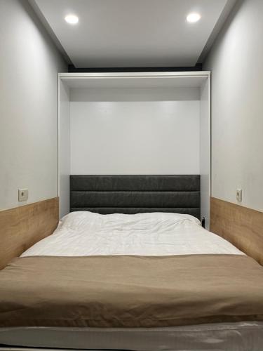 a bed in a bedroom with a large window at Cozy Apartment in Orbi Bakuriani in Bakuriani