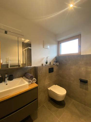 a bathroom with a white toilet and a sink at Ferienwohnungen Moser in Steinberg am Rofan