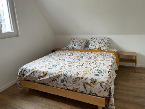 a small bed in a bedroom with a bedspread and pillows at Gite au gré de la Loire piscine et spa in Saint-Mathurin