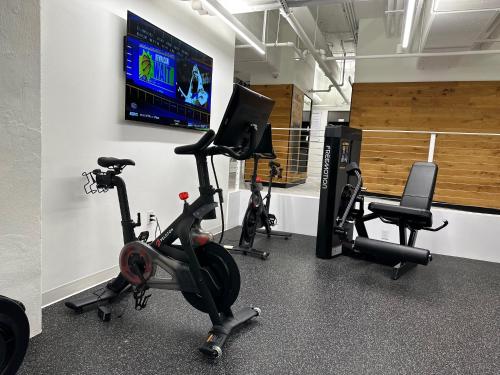a gym with several exercise bikes and a flat screen tv at Mint House Dallas - Downtown in Dallas