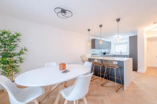 a kitchen and dining room with a white table and chairs at Central 3BD Flat with Balcony in Paddington in London