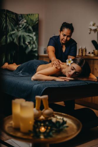 a manties a woman laying on a bed with a table at Five Seasons Szklarska Poręba in Szklarska Poręba
