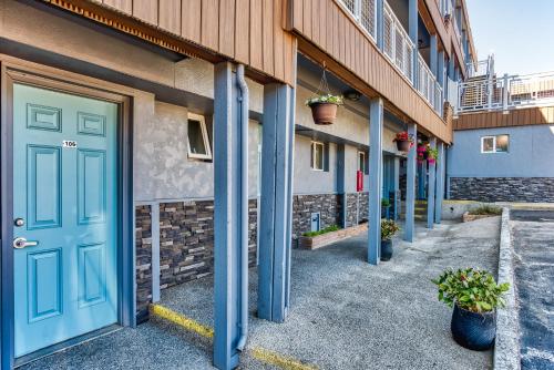 a row of buildings with blue doors and potted plants at Seagull Beachfront Inn in Lincoln City